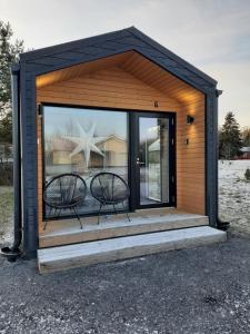 a tiny house with two chairs in it at Willa Rauha G, minikoti rauhallisella sijainnilla, ei saunaa in Lumijoki