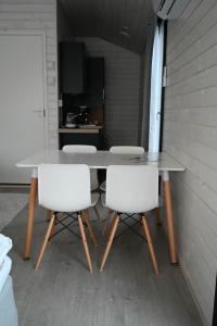 a table and two white chairs in a room at Willa Rauha G in Lumijoki