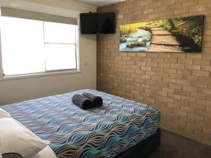 a bedroom with a bed with a cat laying on it at Acacia Caravan Park & Holiday Units in Ararat