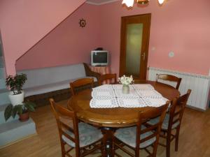 una sala da pranzo con tavolo, sedie e divano di Vacation home Kuća za Odmor a Krasno Polje
