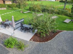 a garden with a table and chairs and a tree at Lovely modern apartment with private terrace in Ellscheid