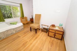a bedroom with a bed and a desk and a table at Nest Holidays Homestay in Kaglipur