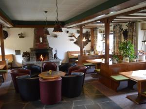a restaurant with tables and chairs and a fireplace at Holiday home in Monschau with sauna in Alzen