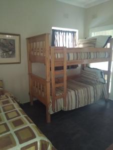 a bedroom with two bunk beds and a bed at Henry's House On Sea in Hibberdene