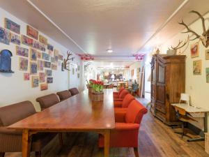 ヴィンターベルクにあるExclusive group house in Winterberg with common room bar and large kitchenのダイニングルーム(木製テーブル、赤い椅子付)