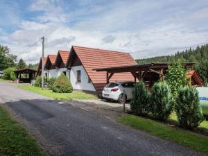 biały samochód zaparkowany przed domem w obiekcie Holiday home in Thuringia with terrace w mieście Friedrichroda