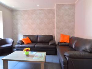 ein Wohnzimmer mit einem Ledersofa und einem Couchtisch in der Unterkunft Lovely modern apartment walking distance from the Mosel shops and restaurants in Zell an der Mosel