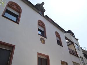 a white building with windows and a clock on it at Zell Riverside Comfort in Zell an der Mosel