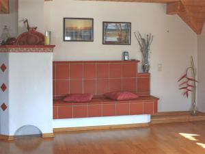 um sofá num quarto com azulejos vermelhos na parede em Beautiful apartment near the lake em Herrischried