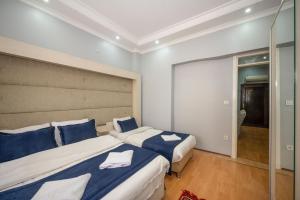 1 dormitorio con 2 camas y almohadas azules y blancas en Taksim Suite-ll, en Estambul