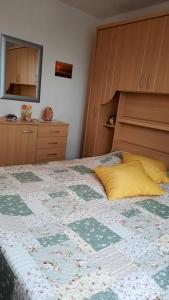 a bedroom with a large bed with a yellow pillow at Kleine Möwe, Fewo mit zwei separaten Schlafzimmern in Heiligenhafen