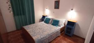 a small bedroom with a bed with blue pillows at Apartments Edita in Rogoznica