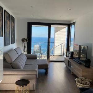 ein Wohnzimmer mit einem Sofa und Meerblick in der Unterkunft Apartment SEA VIEW in Llança