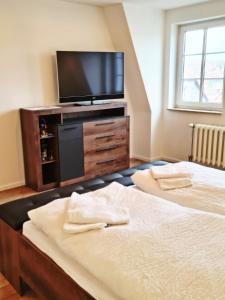 a bedroom with two beds and a flat screen tv at DM Hotels & Apartments - Hotel Deutsches Haus in Dingelstädt