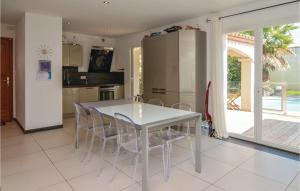 a white table and chairs in a kitchen with a sliding glass door at Cozy Home In Aigues-Mortes With Kitchen in Aigues-Mortes