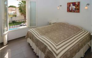 a bedroom with a bed and a large window at Cozy Home In Aigues-Mortes With Kitchen in Aigues-Mortes