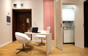 ローマにあるSofia's Suites Guesthouseのテーブルと椅子2脚、キッチンが備わる客室です。