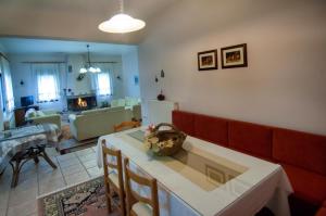 a living room with a red couch and a table at Elati Electra's Cozy House in Elati Trikalon +24 photos