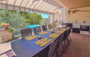 uma mesa azul com cadeiras e uma cozinha num pátio em Stunning Home In Lamotte Du Rhone With 5 Bedrooms, Private Swimming Pool And Outdoor Swimming Pool em Lamotte-du-Rhône