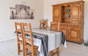 een eetkamer met een tafel en een houten kast bij Stunning Home In St, Marcouf De Lisle With Wifi in Saint-Marcouf