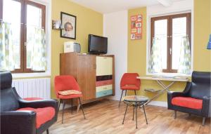 ein Wohnzimmer mit Stühlen, einem TV und einem Schreibtisch in der Unterkunft 3 Bedroom Stunning Home In Le Bourg-dun in Le Bourg-Dun
