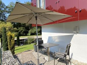 a table and chairs under an umbrella on a patio at Ferienwohnung Rack in Wangen im Allgäu