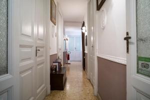 um corredor com portas brancas e piso em azulejo em San Demetrio em Catânia