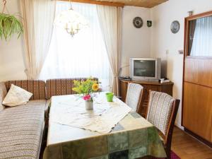 a living room with a table and a television at Enjoy a holiday on the farm in a quiet area in Sellerich