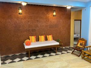 una panchina contro un muro di mattoni con cuscini colorati sopra di Ola Agro Riverside Villa in Malvan, Dhamapur, Sindhudurg a Pendur