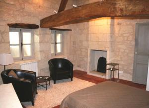 Gite Chateau de Chaintres في Dampierre-sur-Loire: غرفة نوم بها موقد وكراسي وسرير