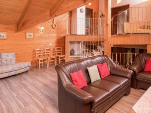 a living room with a leather couch and a table at Holiday home in Lossburg near the ski area in Loßburg