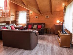een woonkamer met leren banken en een televisie bij Holiday home in Lossburg near the ski area in Loßburg
