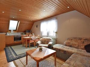 ein Wohnzimmer mit einem Sofa und einem Tisch in der Unterkunft Holiday home near the Klingenthal ski resort in Beerheide