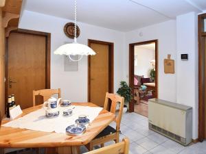 una cucina e una sala da pranzo con tavolo e sedie in legno di Quaint Apartment with Private Terrace Garden a Schiltach