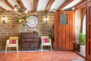 una habitación con dos sillas y un reloj en la pared en Casa rural Ezkonberri, en Unzué
