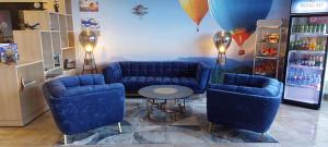 Pokój z dwoma niebieskimi kanapami i stołem w sklepie w obiekcie Sky High Hotel Airport 200 meters from the terminal w Rydze