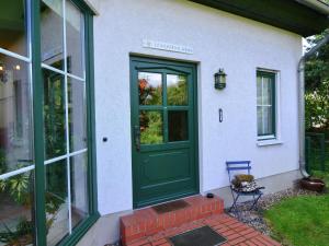 una puerta verde al lado de una casa en Cozy Holiday Home in Kappe with Balcony, en Kappe