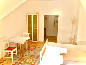 Zimmer mit einem Tisch, Stühlen und einem Bett in der Unterkunft Gästezimmer Puzwidu in Wien