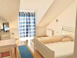 - une chambre blanche avec un lit et une fenêtre dans l'établissement Gästezimmer Puzwidu, à Vienne