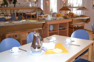 a dining room with a table and blue chairs at Haus der Begegnung Heilig Geist in Burghausen