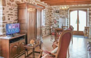a woman sitting in a chair in a living room with a television at Awesome Home In Lesconil With 2 Bedrooms in Plobannalec-Lesconil