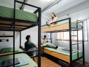 Hybrit hostel&cafe في هات ياي: مجموعة من الناس في غرفة مع سرير بطابقين