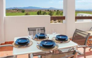 El RomeroにあるBeautiful Apartment In Alhama De Murcia With Kitchenetteの白いテーブル(ブループレート、ワイングラス付)