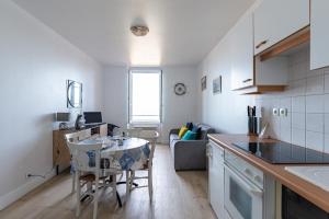 eine Küche und ein Wohnzimmer mit einem Tisch und Stühlen in der Unterkunft Castaline in Saint-Cast-le-Guildo