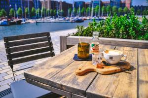 ein Holztisch mit einer Tasse Kaffee und einem Getränk in der Unterkunft Four Elements Hotel in Amsterdam