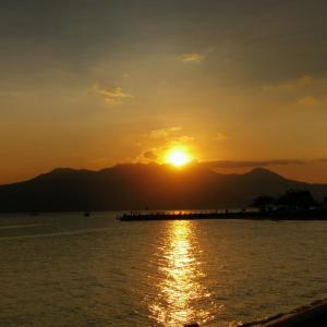 einen Sonnenuntergang über einem Wasserkörper mit einem Pier in der Unterkunft Subic Bay View Diamond Hotel in Olongapo