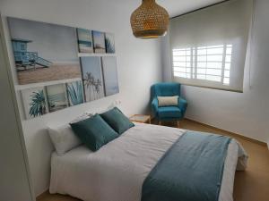 a bedroom with a bed and a blue chair at La Paz del Mediterráneo in Garrucha +24 photos
