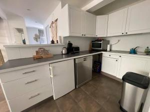 a kitchen with white cabinets and stainless steel appliances at LA MANOSC in Grimaud