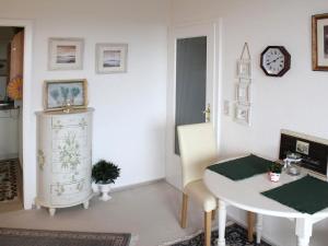 uma sala de estar com uma mesa e um relógio na parede em Flat in Gl cksburg with sea view em Ulstrupfeld