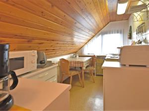 a kitchen with a table with chairs and a microwave at Flat near the forest in Frauenwald Thuringia in Frauenwald